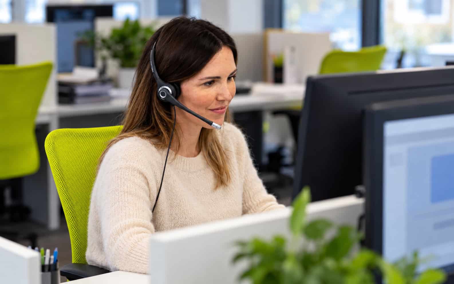 Operatrice di Itacall Group con cuffie al computer, in una scena illustrativa del contatto telefonico con una pubblica amministrazione